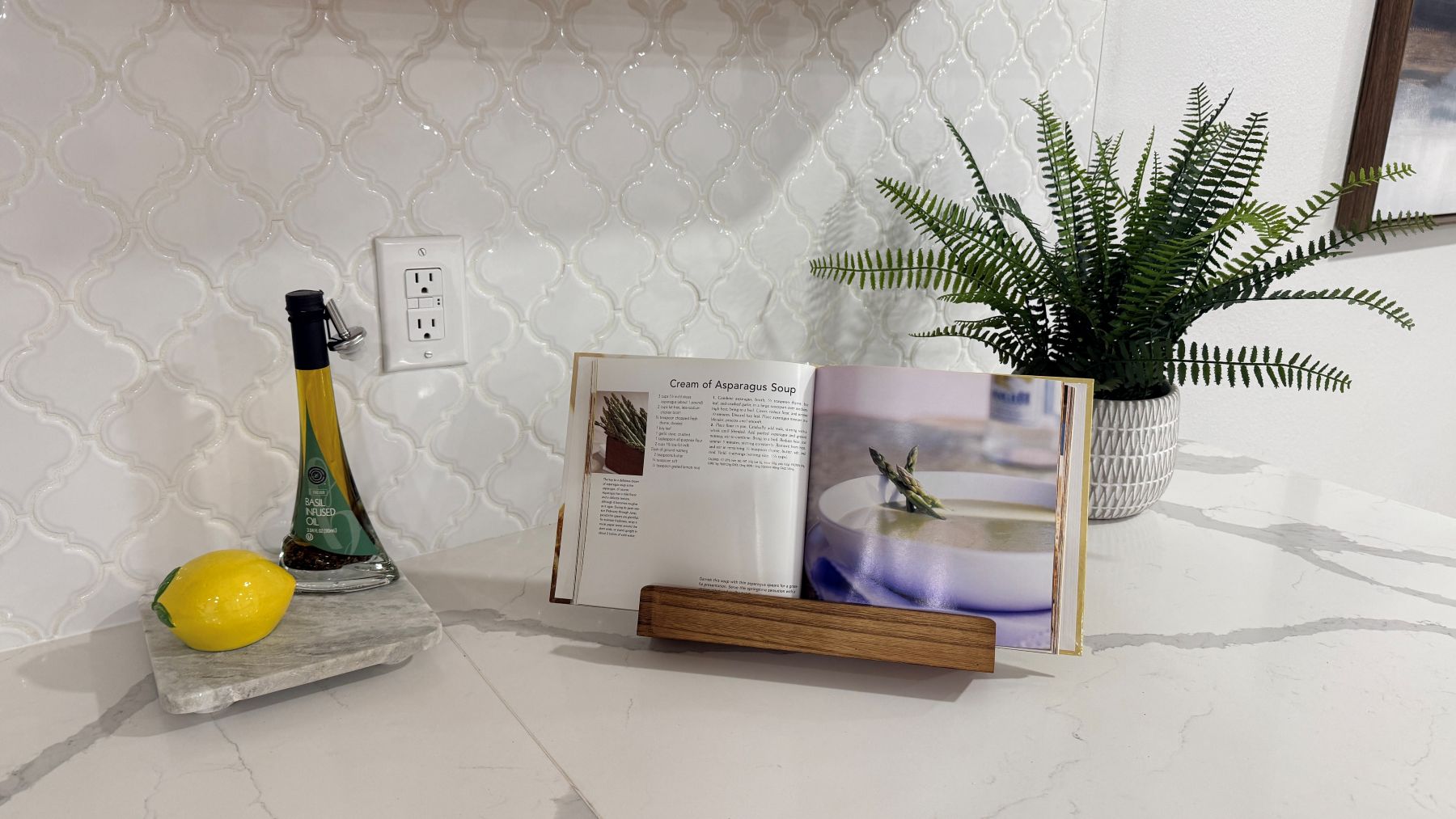 Styled kitchen counter with cookbooks, plant and accessories